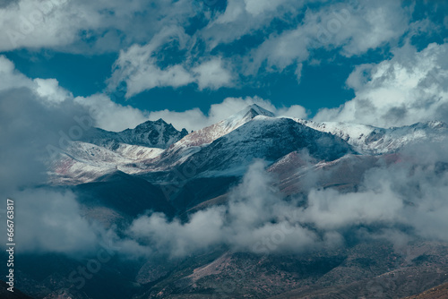 Picturesque mountain landscape with snowy peaks and clouds