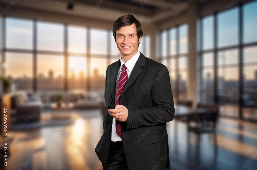 Smiling young businessman work on smartphone in office, AI generated image Smiling young businessman work on smartphone in office, AI generated image