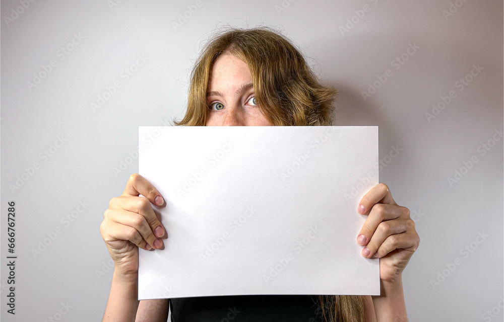 a young girl holds a sheet of paper in her hands a young girl holds a sheet of paper in her hands