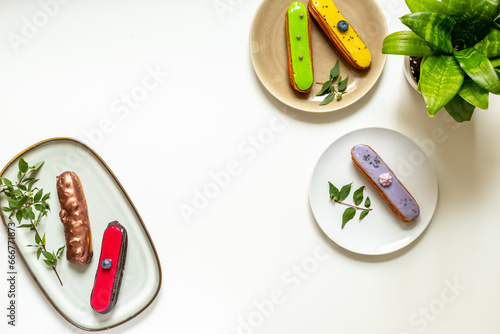 Many various glased eclairs with chocolate and berrie. Sweet food background photo