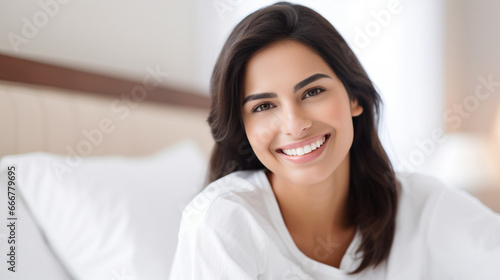 Young Asian woman in hotel room, happy and relaxed on white bed
