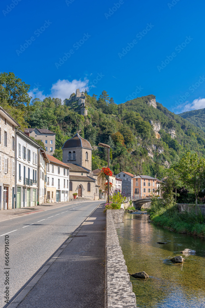 Saint-Rambert-en-Bugey, France - 08 31 2021: Grand Colombier Pass. View of the Albarine river, the road, the church, the castle ruins and the mountain ridge .