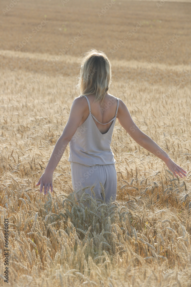 Candid outdoor portrait of young woman in linen outfit in the wheat field. Casual summer fashion. Candid outdoor portrait of young woman in linen outfit in the wheat field. Casual summer fashion.
