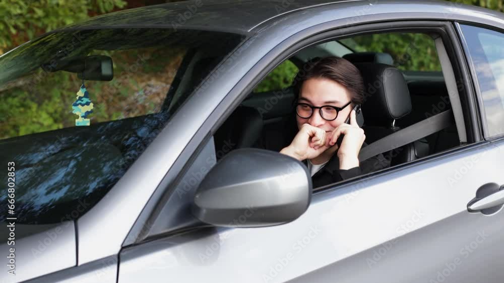 businessman in suit sitting in business car and talking on the phone In woods businessman in suit sitting in business car and talking on the phone In woods