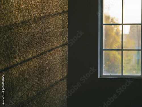 Shadow and light coming in through window onto a textured wall  photo