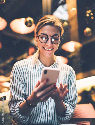 Content adult female browsing smartphone in cafe