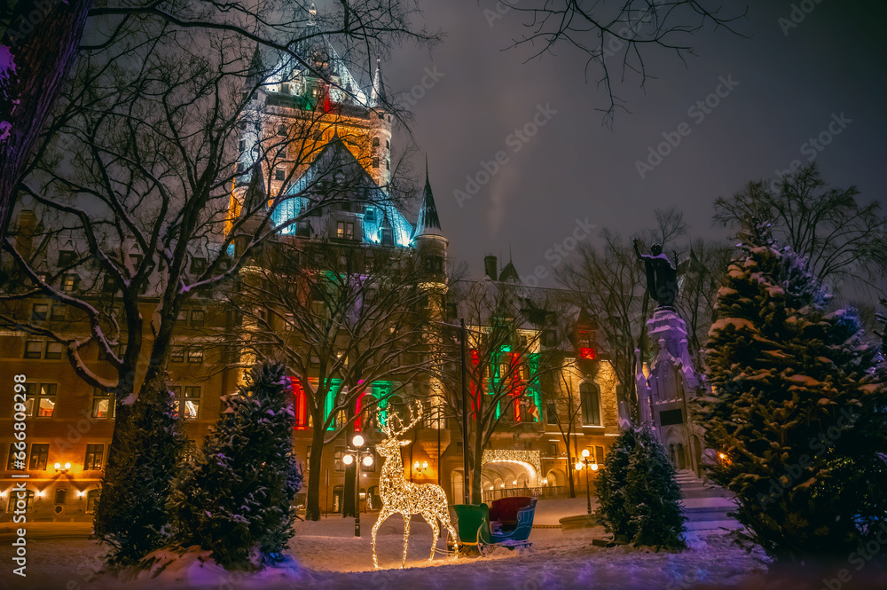 Obraz premium Place d'Armes and historic Fairmont Le Chateau Frontenac hotel during winter holidays, with Christmas decorations including reindeer and sleigh, old Quebec City, Canada. Photo taken in December 2022.