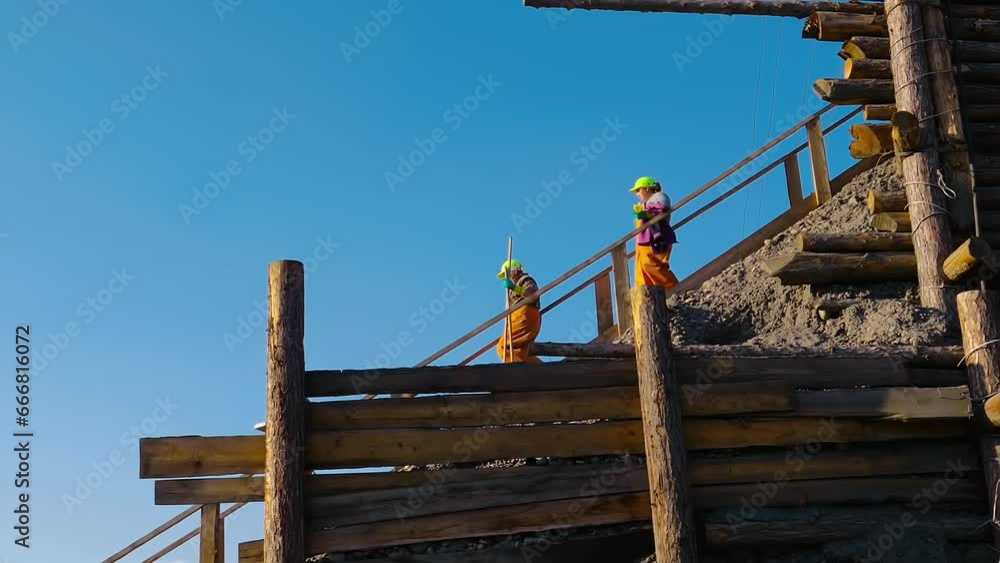 Multiple workers are carrying the mining equipment to the quarry. Workers are going downstairs with the mining equipment in hand. Workers are bringing the mining equipment to the quarry. Labor. Multiple workers are carrying the mining equipment to the quarry. Workers are going downstairs with the mining equipment in hand. Workers are bringing the mining equipment to the quarry. Labor.