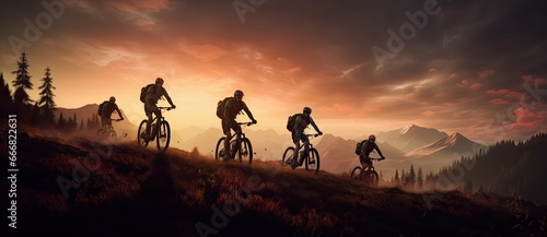 Five mountainbikers riding down a mountain at sunset.