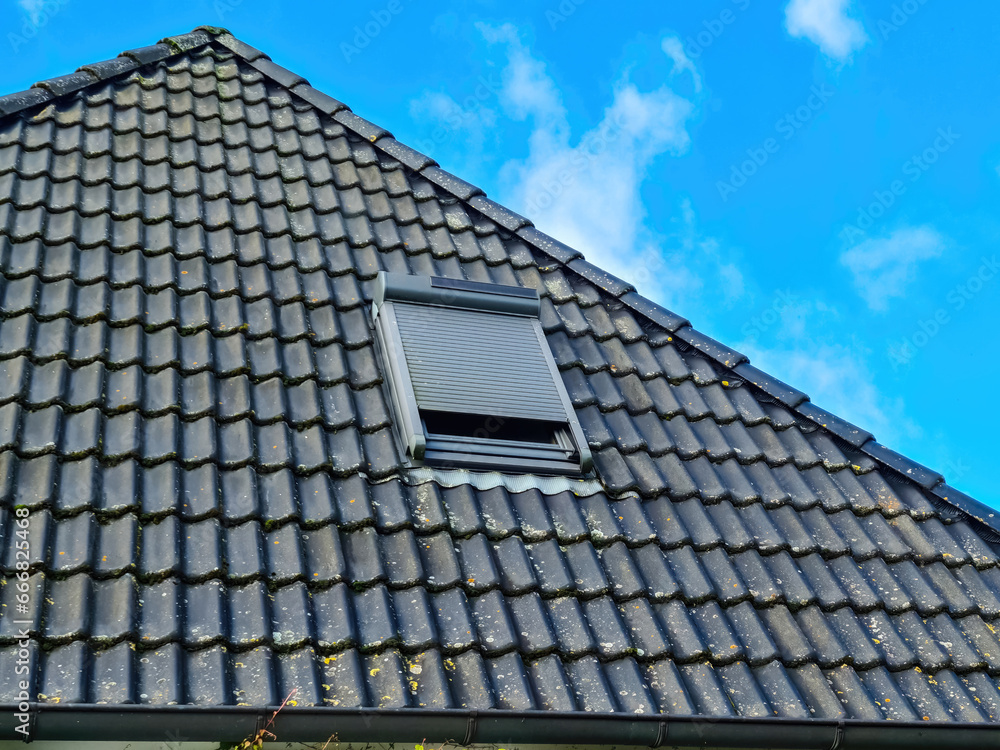 Open roof window in velux style with black roof tiles. Open roof window in velux style with black roof tiles.