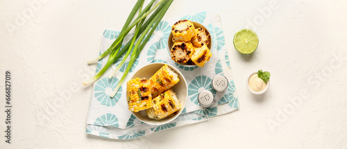 Composition with tasty grilled corn cobs on white background, top view