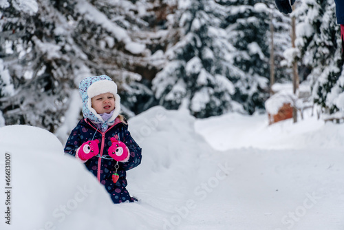 Little girl playing in a deep snow