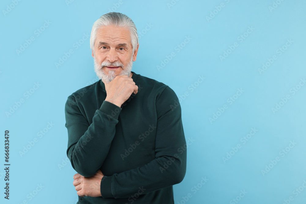 Portrait of handsome senior man on light blue background. Space for text Portrait of handsome senior man on light blue background. Space for text