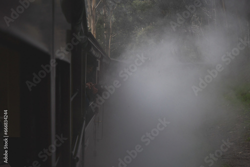 Melbourne Suspension Train, railway. Feet out of the train, smoke and cars. Australia, Belgrave