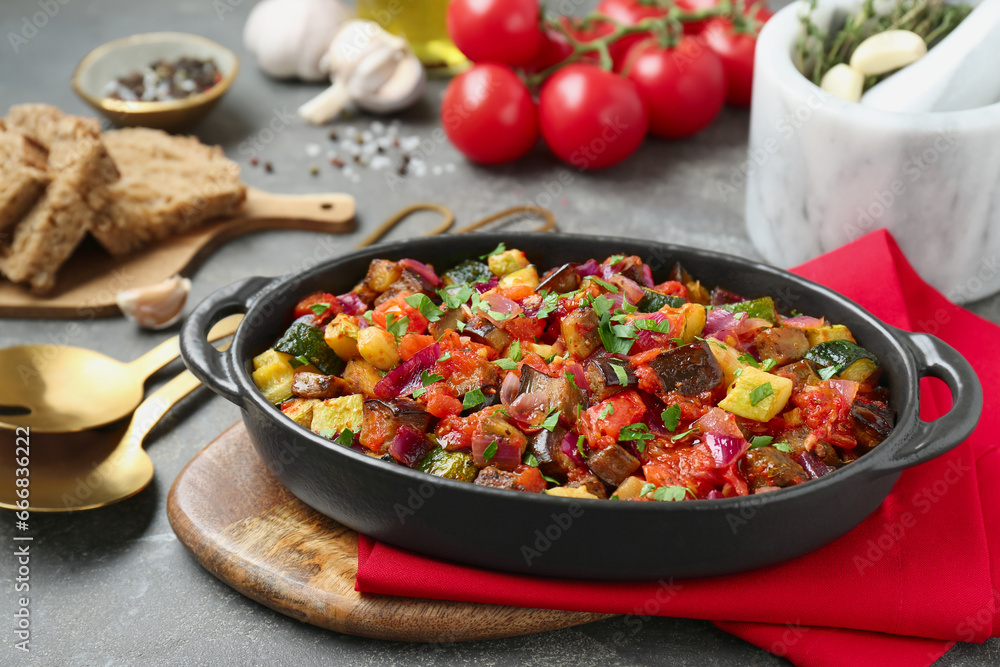 Dish with tasty ratatouille on grey textured table Dish with tasty ratatouille on grey textured table