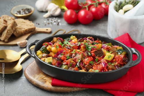 Dish with tasty ratatouille on grey textured table