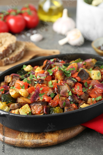 Dish with tasty ratatouille on grey textured table, closeup