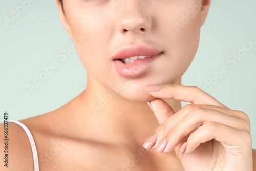 Thoughtful young woman with beautiful lips on green background, closeup