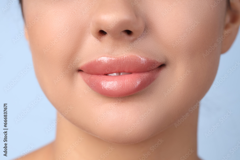 Young woman with beautiful lips on blue background, closeup Young woman with beautiful lips on blue background, closeup