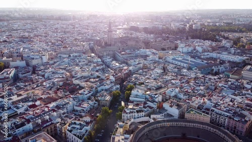 Cityscape Of Seville On Sunny Morning In Spain With Seville Cathedral In View. Bullring Revealed. aerial pullback