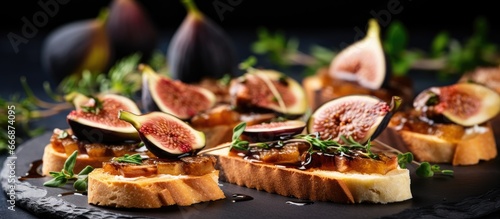 Delicious appetizer on a slate board ideal as an aperitif Canape or crostini with cheese onion jam figs and thyme