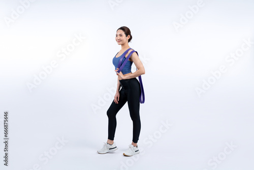 Vigorous energetic woman in sportswear portrait stretching resistance sport band. Young athletic asian woman strength and endurance training session workout routine concept on isolated background.