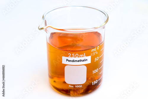 Pendimethalin in glass, Herbicides are used to manage wasteland or control weeds in agriculture photo