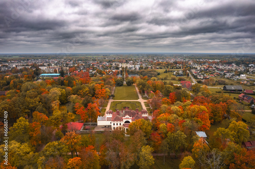 Aerial view of historic Rokiskis manor surrounded by colorful autumn forest