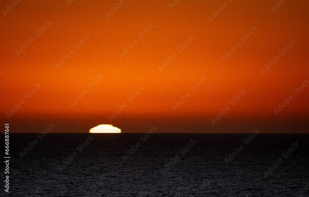 sunset over the sea with deep orange sky 