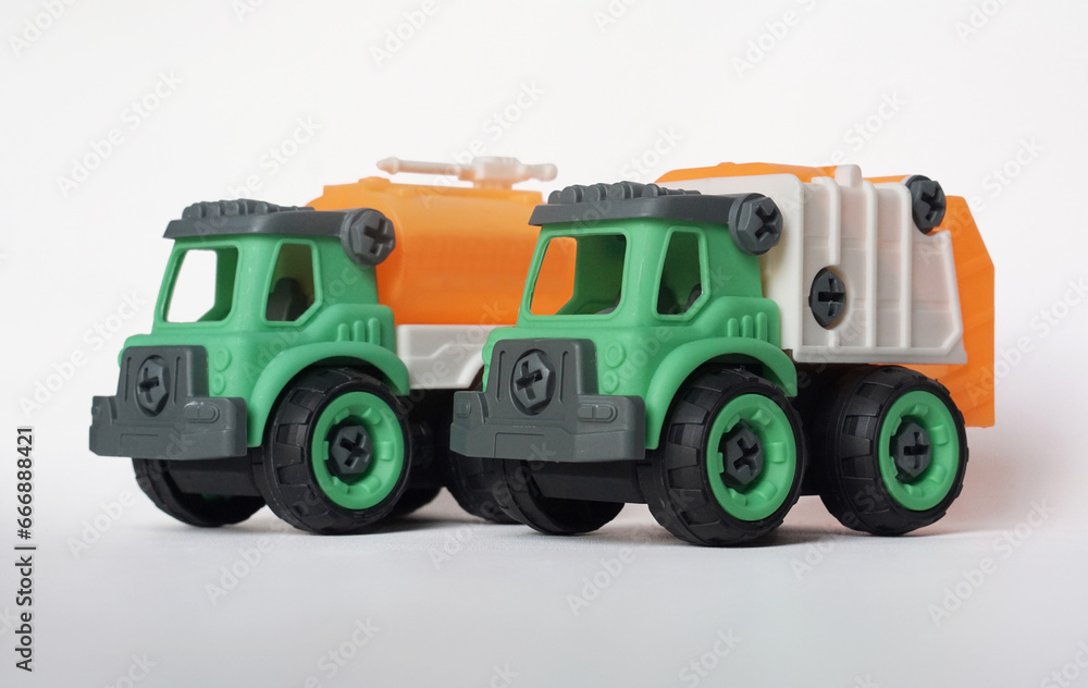 Two DIY plastic truck toy isolated on white background. water truck and garbage truck.