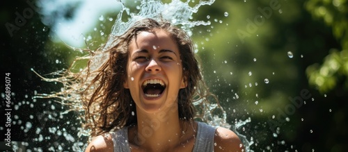 Young woman enjoys a refreshing summer with water play and fun including the ice bucket challenge for a rejuvenating and healthy lifestyle