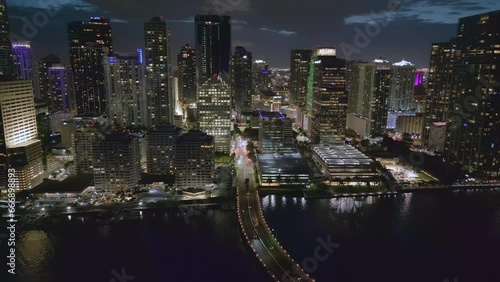 Aerial drone view of Miami Macarthur Causeway Bridge to the beach at night, Florida, USA. Spinning pan shot. photo