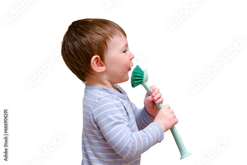 Happy toddler baby with a cleaning brush in the house, isolated on white background. A funny child is holding a large brush in his hands. © Андрей Журавлев