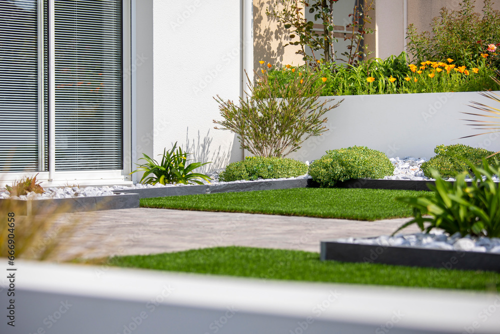 Obraz premium Plante et arbuste dans un jardin moderne au pied d'une maison réalisé par un paysagiste.