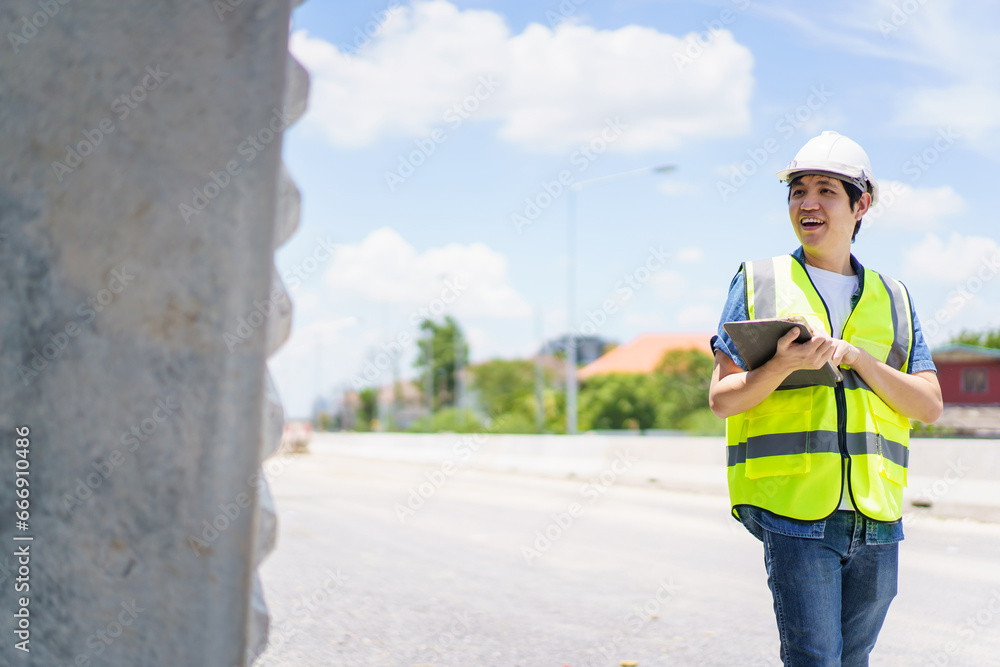 Obraz premium Professional senior Asian civil engineer working at the heavy infrastructure construction site, civil engineer - foreman inspecting the segmentation construction bridge.