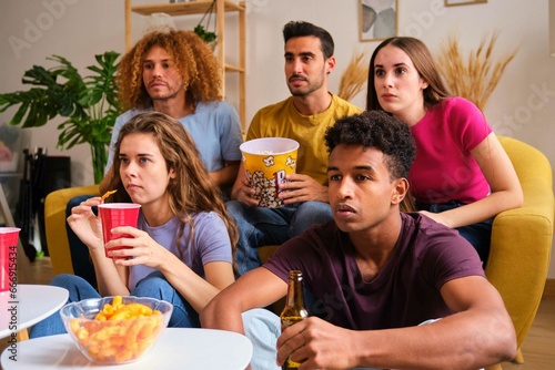 Group of friends watching a thriller interested stared intently.