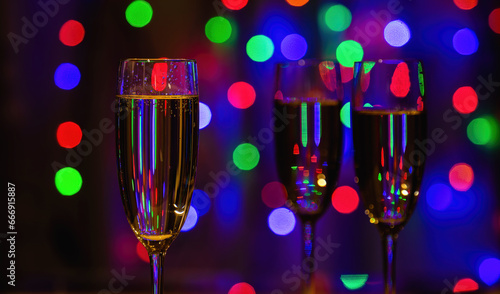 tall glasses of champagne  colorful Christmas lights on the background.