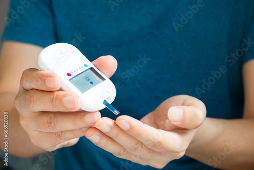 hand of people check diabetes and high blood glucose monitor with digital pressure gauge. Healthcare and Medical concept	 photo