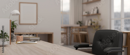 Side view of a space on a wooden table with office accessories in a modern bright office room.