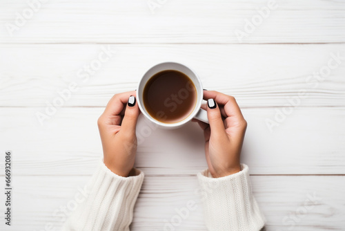 Hands of unrecognizable woman holding empty sheet of paper, Cup of tea and eyeglasses, Studio shot on white wooden background, Flat lay, copy space,