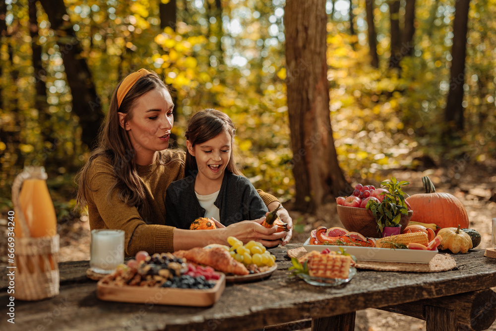 Mother and daughter on a picnic in forest