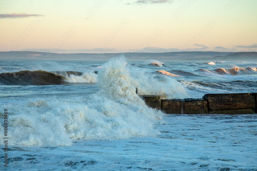 Storm hitting the coast of Scotland with crashing waves coming over a harbour wall Storm hitting the coast of Scotland with crashing waves coming over a harbour wall