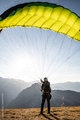 A speedflying pilot ground handling his wing on the launch