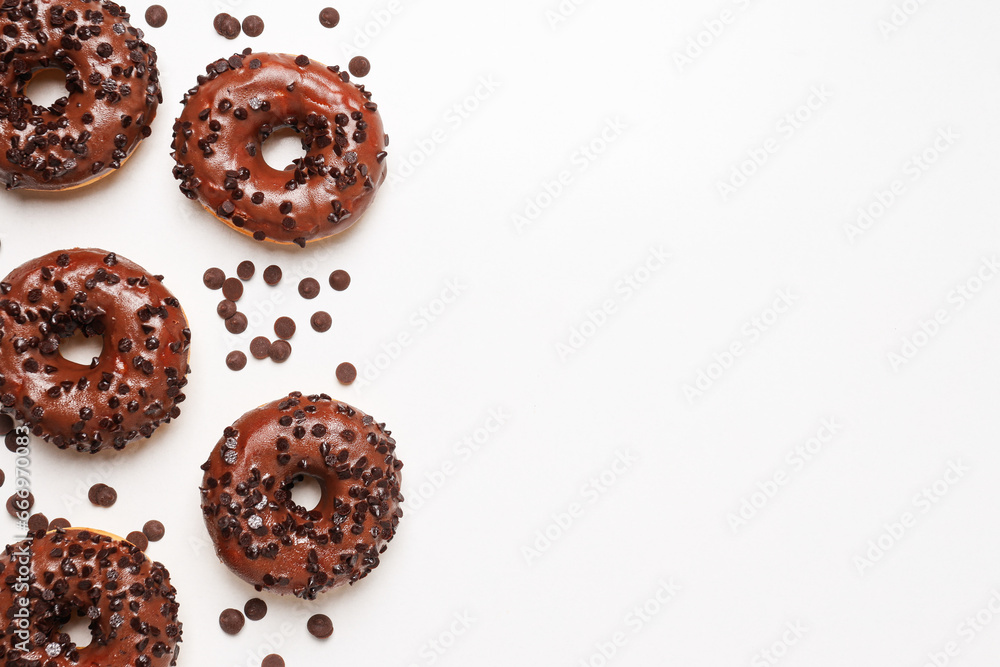 Chocolate donuts and chocolate chips on white background, space for text Chocolate donuts and chocolate chips on white background, space for text