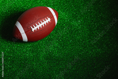 American football ball isolated on green grass
