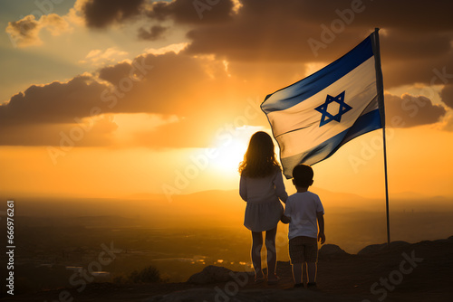 Two little kids with Israel flag on the sunset photo