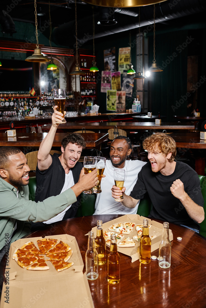 night out, excited interracial men clinking glasses of beer near pizza in bar, male friendship night out, excited interracial men clinking glasses of beer near pizza in bar, male friendship