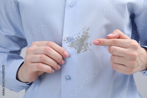 Woman showing stain on her shirt, closeup