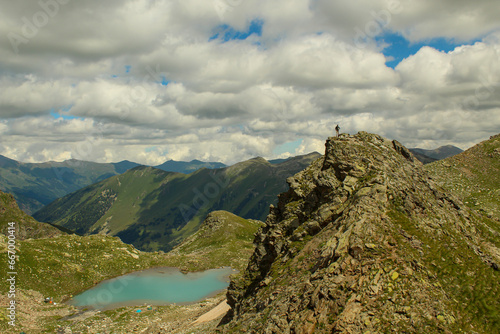 Fototapeta Naklejka Na Ścianę i Meble -  A man standing at the top of the mountain overlooking Sophia lakes, Arkhyz