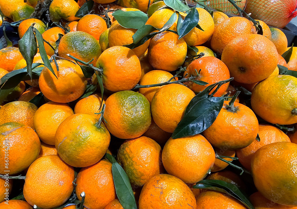 Fresh ripe group mandarins fruit with leaves in shopping mall, Riga. Tasty tangerines close-up Fresh ripe group mandarins fruit with leaves in shopping mall, Riga. Tasty tangerines close-up